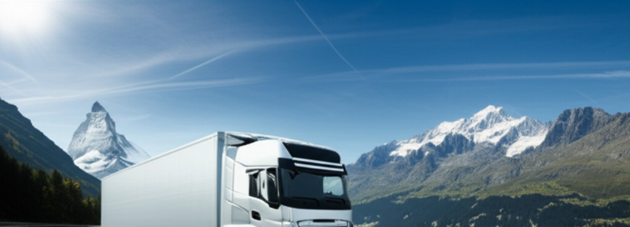 Moderno camion per traslochi in viaggio su un'autostrada panoramica con le Alpi svizzere.