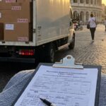 Camion di traslochi a Roma, con il Colosseo sullo sfondo, pronto per un trasloco internazionale.