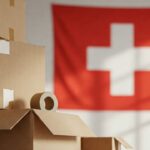 Scatole impilate con bandiera svizzera sullo sfondo, rappresentazione di un trasloco in Svizzera